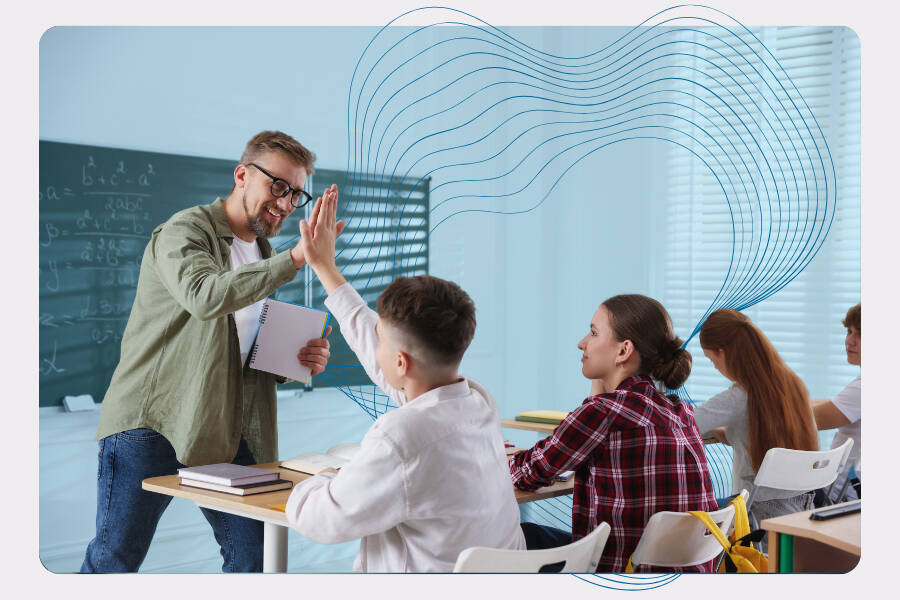 Teacher high-fiving a student in a classroom while other students work at their desks.